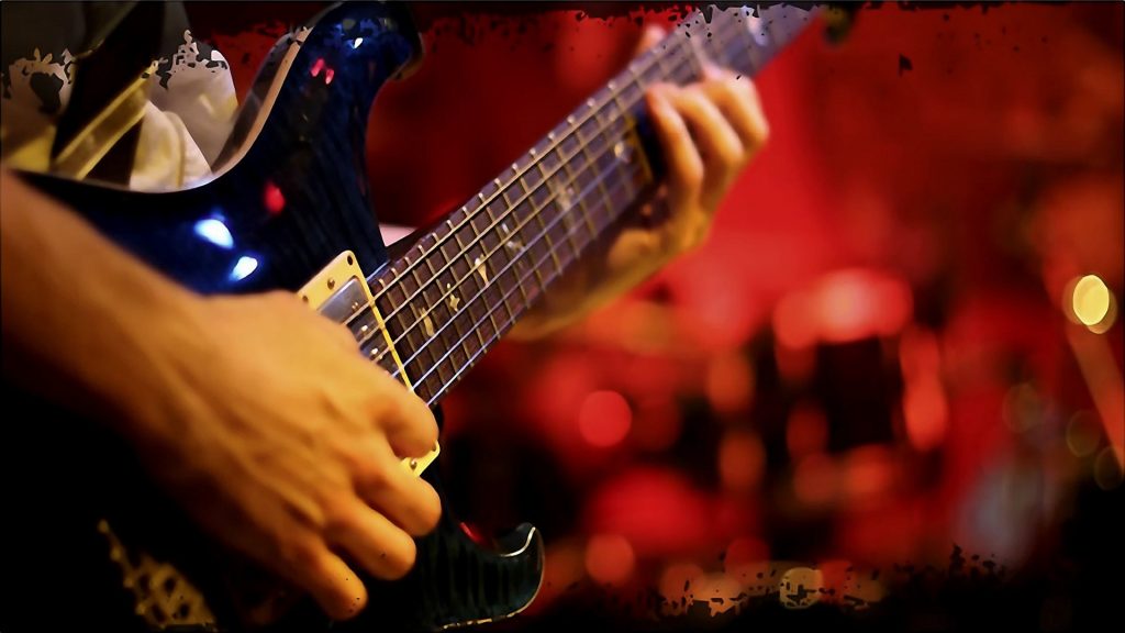 A Close-up iew of a man plays a bass guitar.