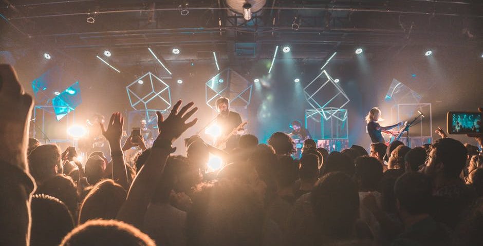 Image Showing that the audience cheering up the musicians in a musical concert.