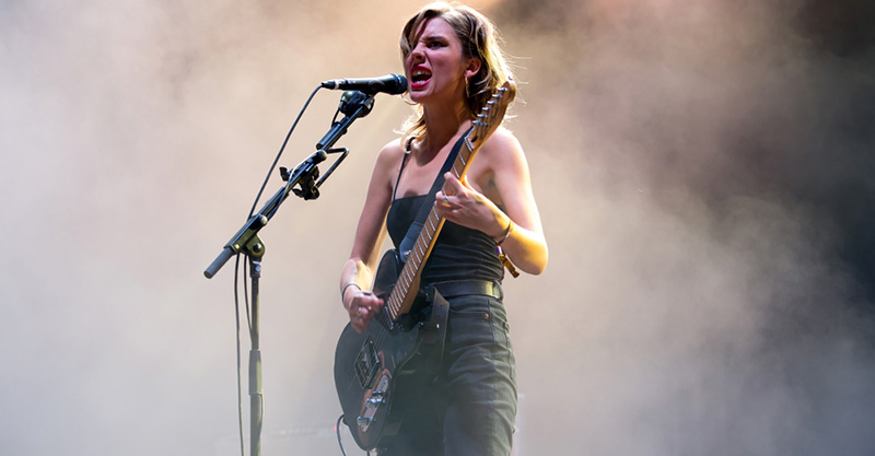 Image showing a beautiful girl with guitar performing in the stage in a smoke background.