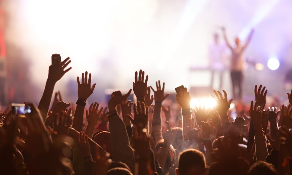 Image of a crowd surfing in the musical concert.